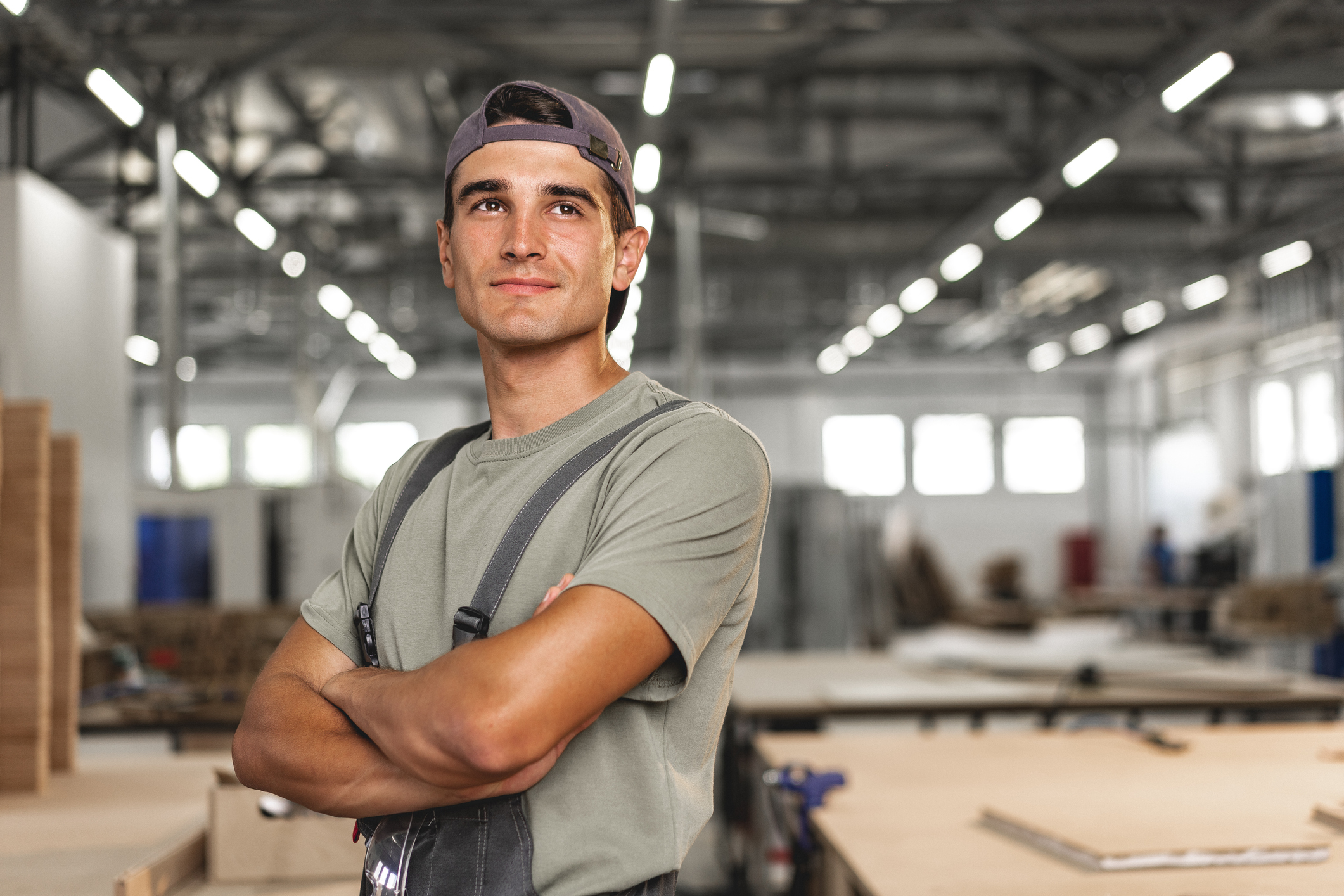 Portrait of young male carpenter standing in the wood workshop